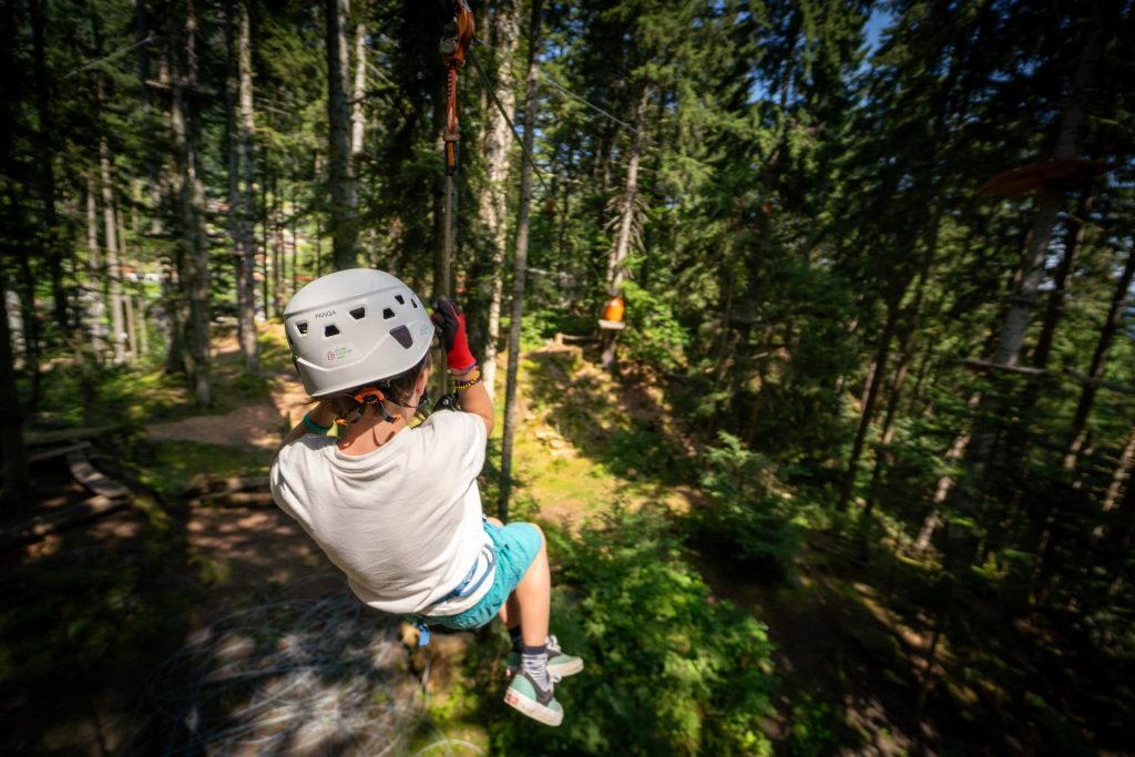 Obiskovalci uživajo na novi zipline progi v Organic Adventure Parku v Švici.